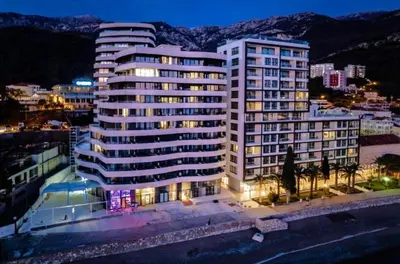 a large white building in a city at night at Beachfront luxury apartment in Budva
