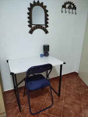 a table with a chair and a mirror on the wall at Daydream Apartment in Podgorica in Podgorica