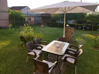 a table and chairs under an umbrella in a yard at Daydream Apartment in Podgorica in Podgorica