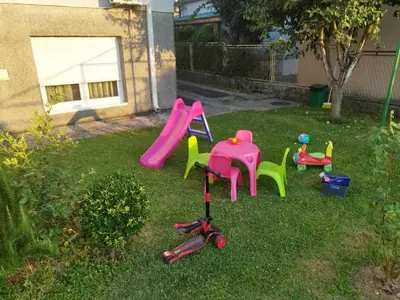 a group of chairs and a slide in a yard at Daydream Apartment in Podgorica in Podgorica