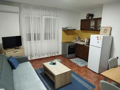a living room with a couch and a refrigerator at Daydream Apartment in Podgorica in Podgorica