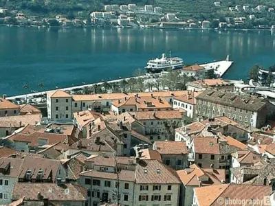 a city with buildings and a boat in the water at Bond studios- Old town in Kotor