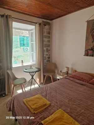 a bedroom with a bed and a table and a window at Bond studios- Old town in Kotor
