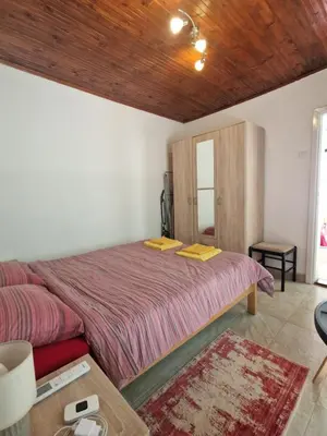 a bedroom with a large bed and a wooden ceiling at Bond studios- Old town in Kotor
