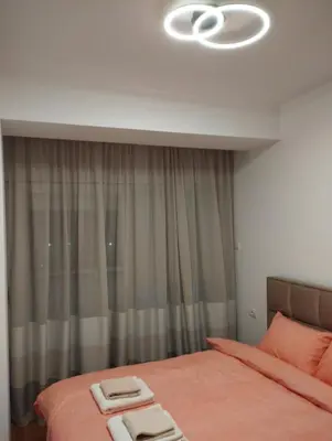a bedroom with a bed with two towels on it at South Side Apartment in Podgorica