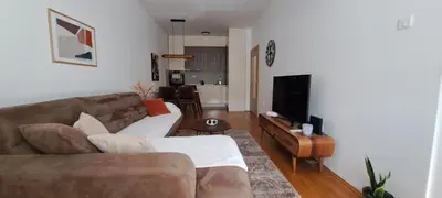 a living room with a couch and a flat screen tv at South Side Apartment in Podgorica
