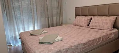 a bedroom with a bed with two towels on it at South Side Apartment in Podgorica
