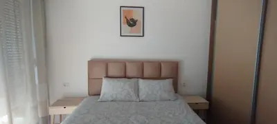 a bedroom with a bed and a picture on the wall at South Side Apartment in Podgorica