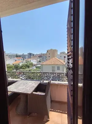 a table and chairs on a balcony with a view of a city at Villa Roselina By Beatrix in Budva