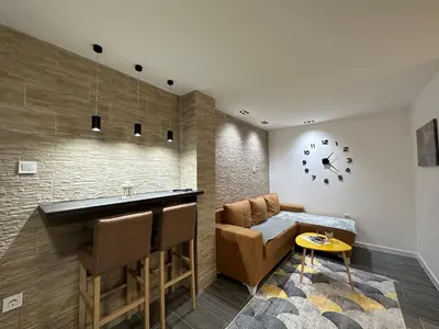 a kitchen with a bar and a counter and a table at Vucinic Studio Apartment in Cetinje