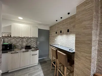 a kitchen with wooden cabinets and a counter top at Vucinic Studio Apartment in Cetinje