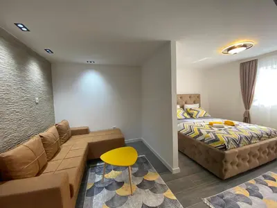 a bedroom with a bed and a couch at Vucinic Studio Apartment in Cetinje
