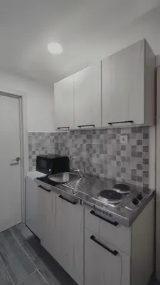 a kitchen with white cabinets and a stove top oven at Vucinic Studio Apartment in Cetinje