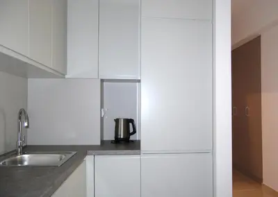 a kitchen with white cabinets and a sink at Status-M Аpartments 133 in Becici