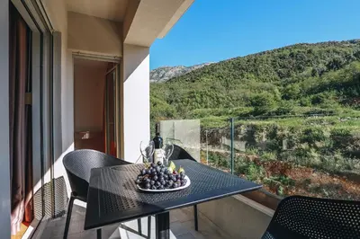 a table with a bowl of fruit on a balcony at Status-M Аpartments 133 in Becici