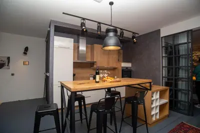 a kitchen with a wooden table and black chairs at The Old Town Luxury Apartment by Montenegro Moments in Kotor