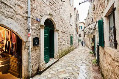 an alley in an old town with people walking down it at The Old Town Luxury Apartment by Montenegro Moments in Kotor