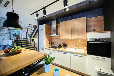 a kitchen with white cabinets and a table with a bowl of fruit at The Old Town Luxury Apartment by Montenegro Moments in Kotor