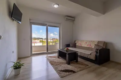a living room with a couch and a large window at AS Apartments in Ulcinj