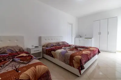 two beds in a white room with at AS Apartments in Ulcinj