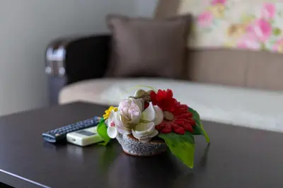 a vase of flowers on a table with a remote control at AS Apartments in Ulcinj