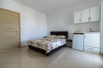a small bedroom with a bed and a kitchen at AS Apartments in Ulcinj