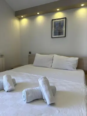 a white bed with towels on top of it at Vila Centar in Budva