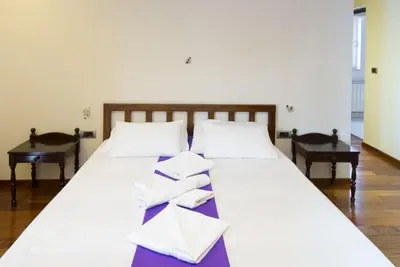 a large white bed with white pillows on it at Vila Centar in Budva