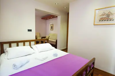 a bedroom with a large bed with a purple blanket at Vila Centar in Budva