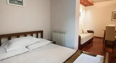 a bedroom with a bed and a couch and a chair at Vila Centar in Budva