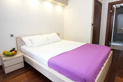 a bedroom with a large bed with a purple blanket at Vila Centar in Budva