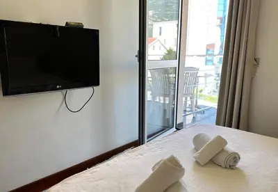 a bedroom with a flat screen tv and a bed with towels at Vila Centar in Budva