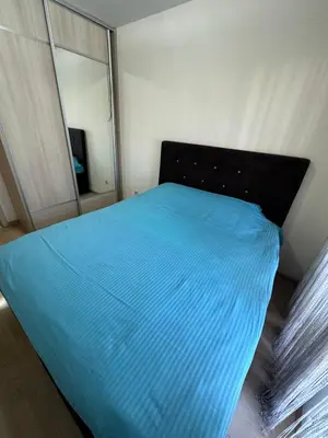 a bedroom with a blue bed with a mirror at City kvart 1 bedroom apartment in Podgorica
