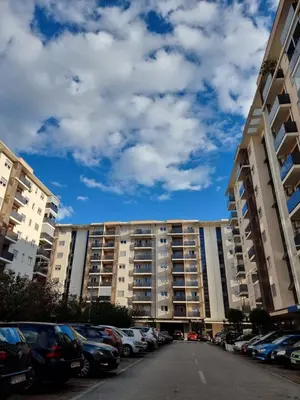 a large building with cars parked in a parking lot at City kvart 1 bedroom apartment in Podgorica