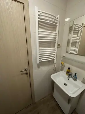 a white bathroom with a sink and a mirror at City kvart 1 bedroom apartment in Podgorica