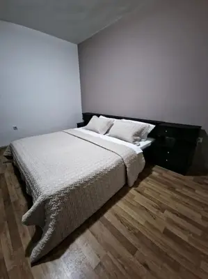 a bedroom with a large bed with white sheets and pillows at Olive's apartment in Podgorica