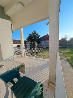 a porch with a green bench and a fence at Olive's apartment in Podgorica