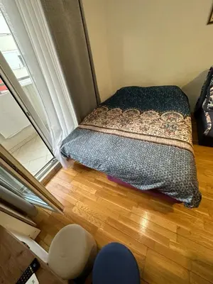a small bedroom with a bed and a window at Ania apartment in Podgorica