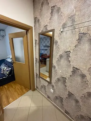 a hallway with a wall with a mirror at Ania apartment in Podgorica