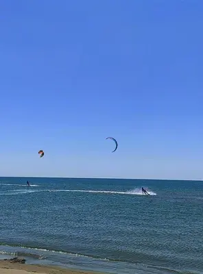 two people kite surfing in the ocean on the beach at Montenegrina apartment in Ulcinj