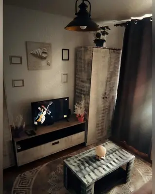 a living room with a flat screen tv and a table at Montenegrina apartment in Ulcinj