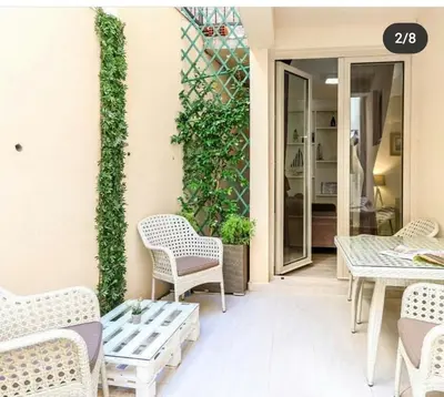 a patio with chairs and tables and a ivy wall at Apartman Petra in Pržno