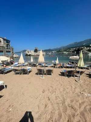 a group of chairs and tables on a beach at Apartman Petra in Pržno