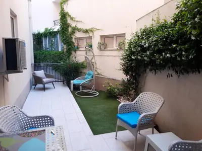 a small patio with chairs and a yard withgrass at Apartman Petra in Pržno