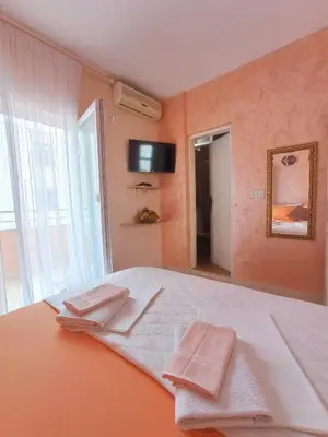 a bedroom with a large bed with two towels on it at Apartmani Andrijana in Ulcinj