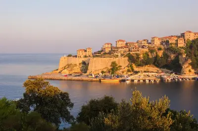 a town on a hill next to a body of water at Apartmani Andrijana in Ulcinj