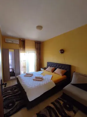 a bedroom with a large bed and a couch at Apartmani Andrijana in Ulcinj