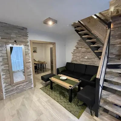 a living room with a couch and a staircase at Apartman Anna Budva in Budva