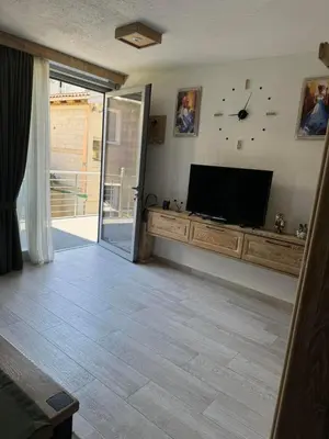 a living room with a flat screen tv on a wall at Apartman Anna Budva in Budva
