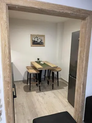 a dining room with a table and a refrigerator at Apartman Anna Budva in Budva